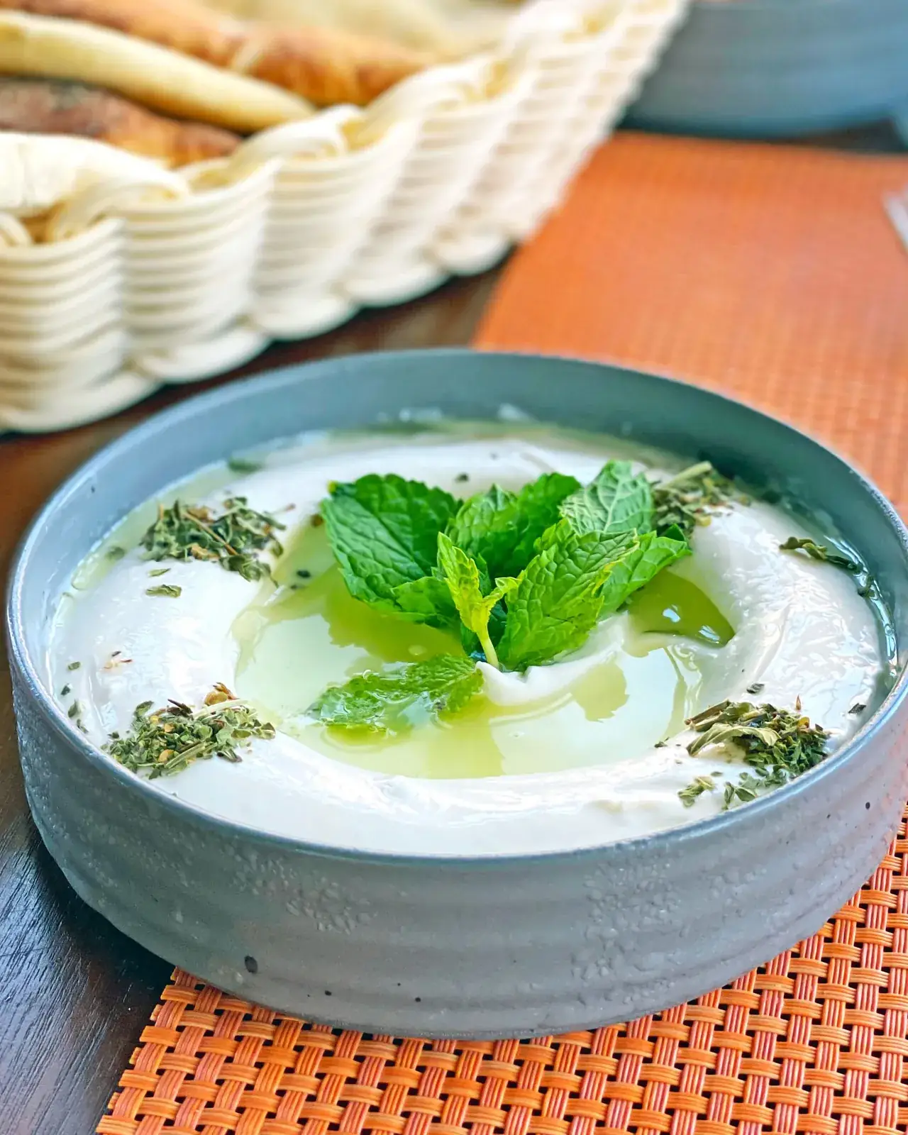 کاسهی ماست با نعنای تازه و روغن زیتون روی میز